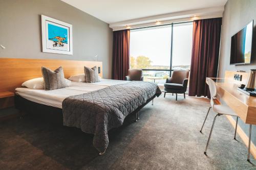 a hotel room with a large bed and a desk at Sankt Jörgen Park in Gothenburg