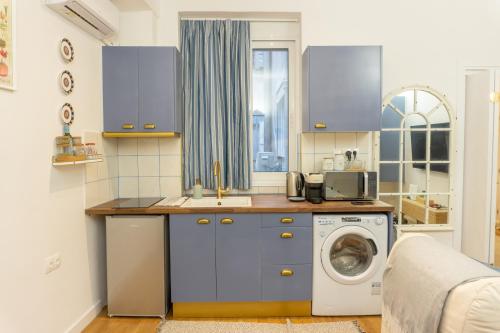 een keuken met een wastafel en een wasmachine bij Casa Thisseos in Athene