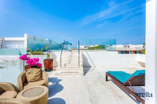 a patio with chairs and tables on a roof at A-Nah Apartments, Rooftop Pool, walking distance to 5th avenue in Playa del Carmen
