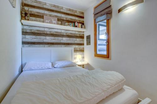 モルジヌにあるMorzine 1000のベッドと木の壁がある寝室