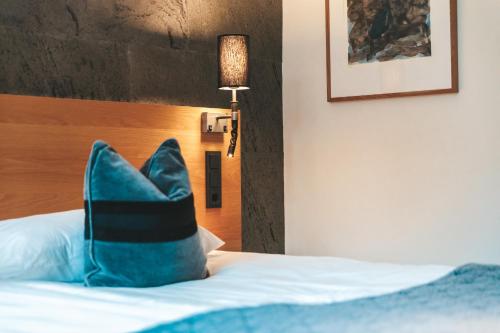 a bed with a blue pillow sitting on top of it at Sankt Jörgen Park in Gothenburg