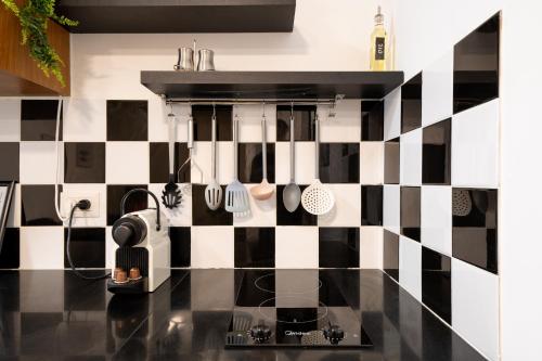 a kitchen with a black and white checkered wall at Haifa PORT Patio Apartment 2 BDRM in Haifa