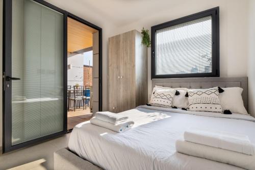 una camera da letto con un grande letto bianco con una grande finestra di Haifa PORT Patio Apartment 2 BDRM a Haifa