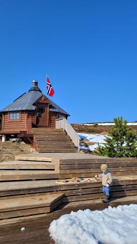 a little boy standing in front of a building at Haramsøy One Night Glamping- Island Life North- overnight stay in a tent set up in nature- Perfect to get to know Norwegian Friluftsliv- Enjoy a little glamorous adventure in Haram