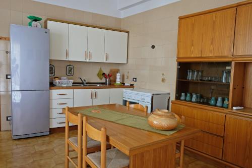 una cucina con tavolo e frigorifero bianco di Guest House Ancora a Pozzallo