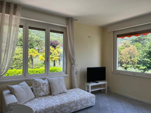 Una sala de estar con un sofá y dos ventanas. en Le luci sul lago, en Predore