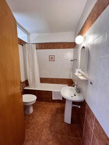 a bathroom with a sink and a toilet and a tub at Sirena Kings in Paphos