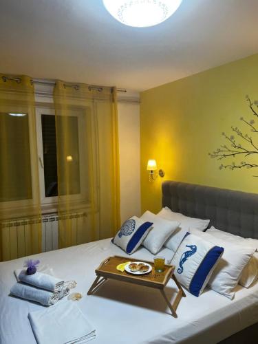 a bed with white pillows and a tray on it at Dolce vita Apartment in Senj