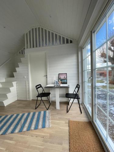 a room with a table and chairs and a staircase at Lyckan - Minihus i lantlig miljö in Ulricehamn