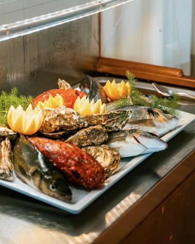 a plate of fish and other foods on a counter at Hotel Lido Beach PHG in Oristano