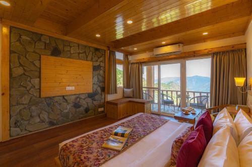 a bedroom with a bed and a stone wall at StayVista at Sarog Cottage at Daafi in Shimla