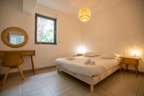 une chambre avec un lit, un miroir et une chaise dans l'établissement Villa Malibu by Connexion, à Mandelieu-la-Napoule