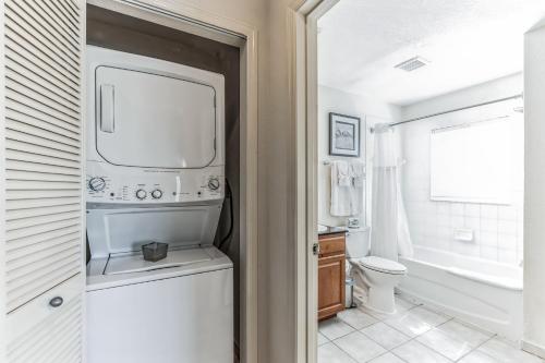 uma casa de banho com um lavatório, um WC e uma janela. em Pirate Ship Resort Condo em Orlando