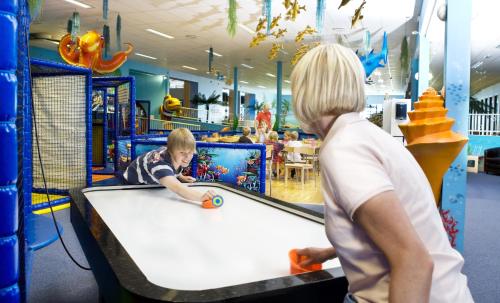 a woman watching a young boy play a game of pool at Pite Havsbad Piteå in Piteå