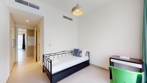 a small bedroom with a bed and a tv at Key View - Maple 2 in Dubai