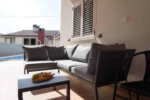 een woonkamer met een bank en een tafel bij Apartments Proxima in Trogir