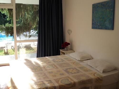 een slaapkamer met een bed en een groot raam bij Hotel Horizont in Goudstrand