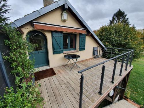 a wooden deck with a green door and a house at Gite de la Drouette et chambre d'hôtes in Villiers-le-Morhier
