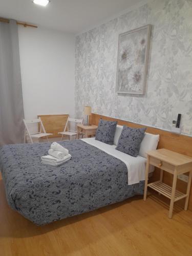 - une chambre dotée d'un lit avec des draps bleus et blancs dans l'établissement Salomé, à Madrid
