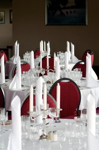 a table with white candles on it with red chairs at Pite Havsbad Piteå in Piteå