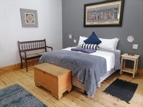 a bedroom with a large bed and a bench at Biki Plek in Kimberley