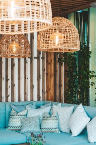 a blue couch with pillows sitting under two hanging lights at Sankt Jörgen Park in Gothenburg