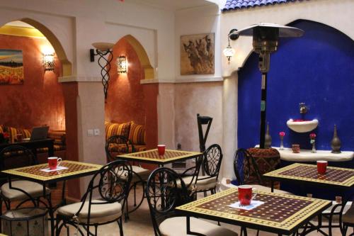 a restaurant with tables and chairs with red cups on them at Riad M'boja "Chez Ali Baba" in Marrakesh