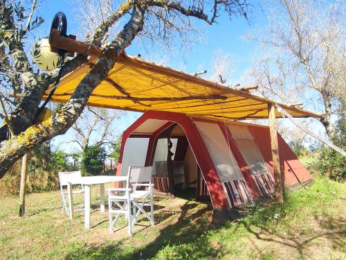 Tienda de campaña roja y blanca con mesa y sillas en Camping Terreno-Ro-Bi-Li, en Cutrofiano