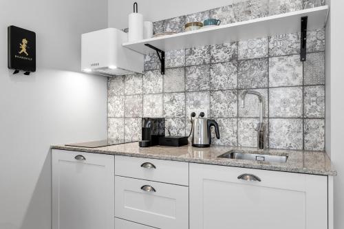 a kitchen with white cabinets and a sink at The Swan House by Heimaleiga in Reykjavík