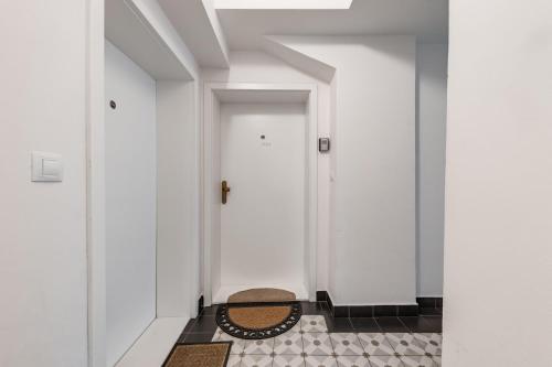 a hallway with two white doors and a rug at Apartments With The Lions in Prague
