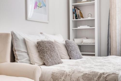 a bedroom with a white bed with pillows on it at Apartments With The Lions in Prague