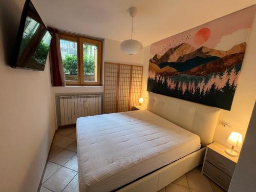 a bedroom with a bed and a painting on the wall at APPARTAMENTO PRIMOLO - CHIESA IN VALMALENCO in Chiesa in Valmalenco