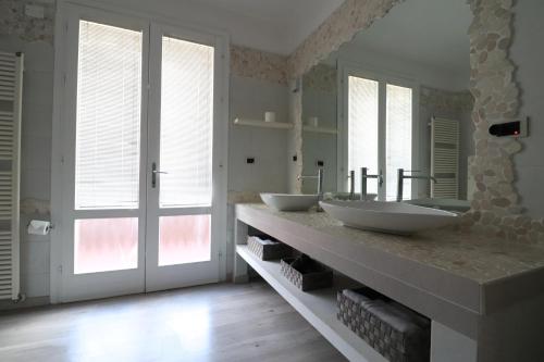 un bagno con due lavandini su un bancone con finestre di Villa Roberta B&B a Ferrara