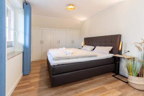 1 dormitorio con 1 cama grande y cabecero negro en Villa Jala, en Dänschendorf