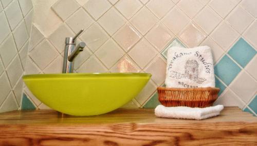 a green bowl on a wooden counter with a towel at Timessa Mezonette - Agios Kirikos in Agios Kirykos