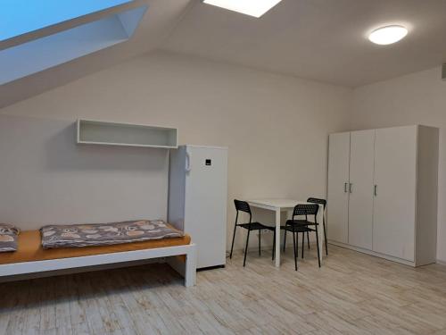 ストゥパヴァにあるWork&Home Stupavaのベッド、テーブル、椅子が備わる客室です。