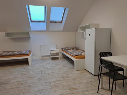 Cette chambre comprend deux lits, une table et des chaises. dans l'établissement Work&Home Stupava, à Stupava