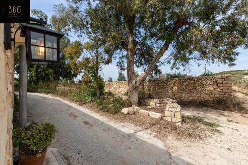 un feu de rue à côté d'un mur de briques avec un arbre dans l'établissement Peaceful, comfy 1BR Nature Retreat: Serene Bliss by 360 Estates, à Mġarr