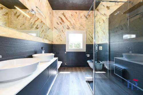a bathroom with two sinks and two toilets at DesenzanoLoft Villa Meraviglia in Desenzano del Garda