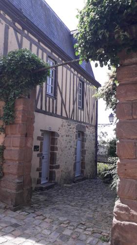 an old building with a brick wall and a building at Petite Maison Romantique au calme, Cœur Historique, vue Ville et Jardin in Le Mans