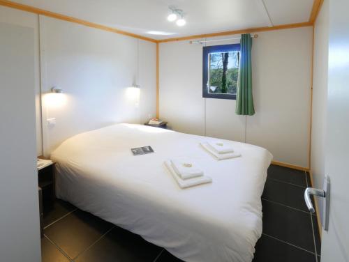 a bedroom with a large white bed and a window at ULVF Le Domaine de Pelvezy in Saint-Geniès