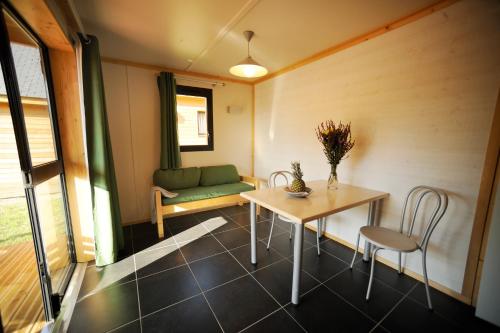 une pièce avec une table, des chaises et un canapé dans l'établissement ULVF Le Domaine de Pelvezy, à Saint-Geniès