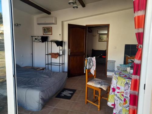 1 dormitorio con 1 cama, 1 silla y 1 puerta en Maison d'une chambre avec jardin clos et wifi a Martigues a 1 km de la plage, en Martigues