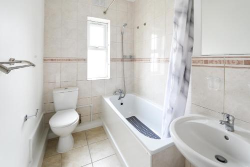 a bathroom with a toilet and a tub and a sink at 2BR Hendon Flat - Free Parking & Bus stop outside in Hendon
