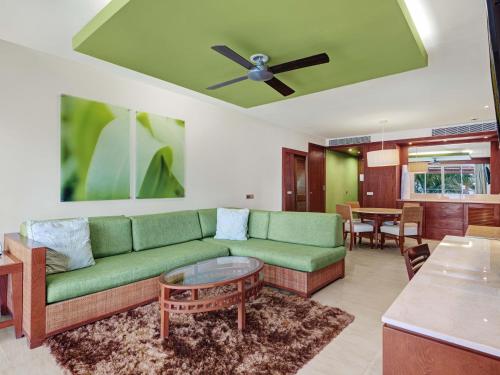 a living room with a green couch and a table at Barceló Bávaro Palace All Inclusive in Punta Cana