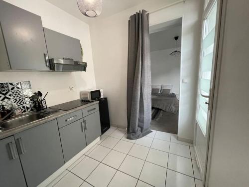 une cuisine blanche avec un évier et une fenêtre dans l'établissement Bizanos - 4 pers, wifi, balcon, à Bizanos