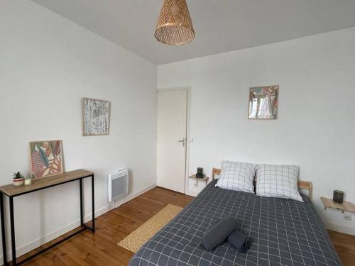 une chambre avec un lit avec une couverture bleue dans l'établissement Bizanos - 4 pers, wifi, balcon, à Bizanos