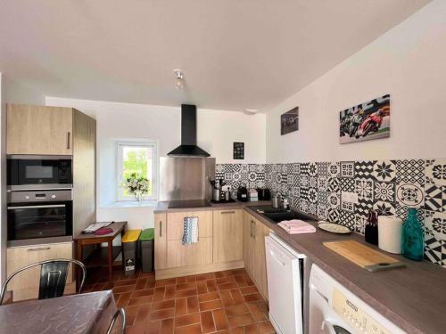 une cuisine avec une cuisinière et un comptoir dans l'établissement Location à la campagne, à Saint-Mars-de-Locquenay