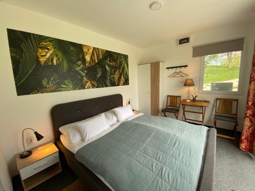 1 dormitorio con 1 cama y una gran pintura en la pared en JANUS COUNTRY SITE Üdülőházak en Szakcs