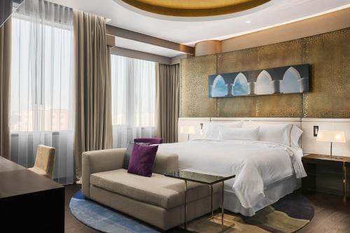 Habitación de hotel con cama y silla en The Westin Doha Hotel & Spa en Doha